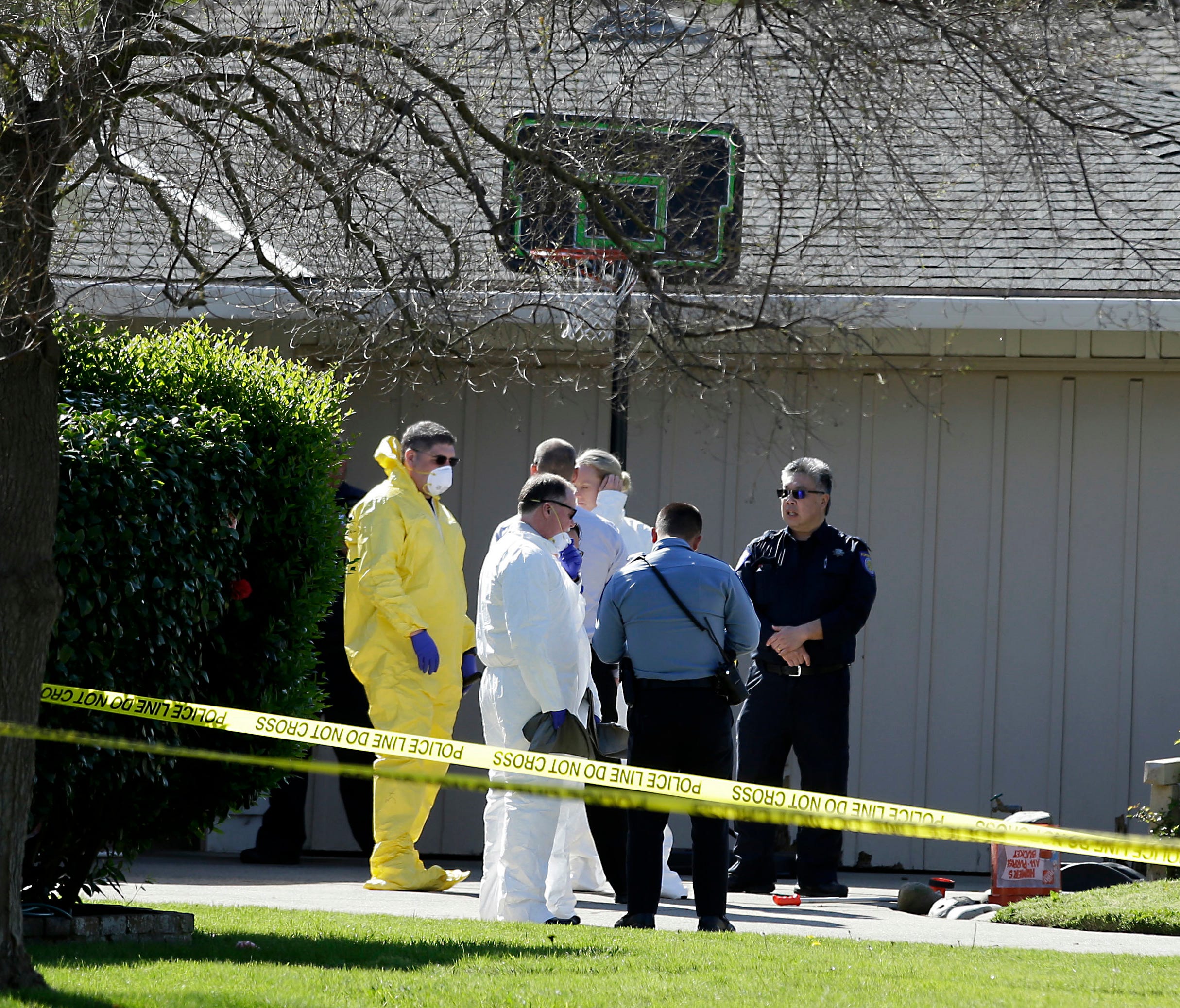 Investigators gather outside a home where four people were found dead, Thursday, March 23, 2017, in Sacramento, Calif.