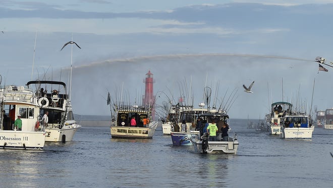 A band of boats head out to Lake Michigan under an arc of water sprayed from a fire truck during the June 22 Blessing of the Fleet in Algoma.