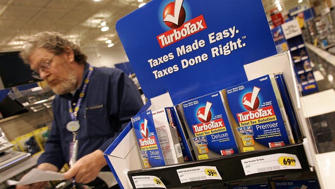 A Best Buy employee walks past a display for TurboTax software.