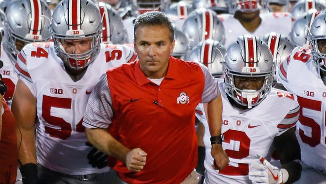 Ohio State coach Urban Meyer leads his team onto the field for an NCAA college football game against Oklahoma in Norman, Okla. Meyer and the Buckeyes coaches did new Rutgers coach Chris Ash a solid this past summer by satellite camping at the Scarlet Knights camp the same day Michigan coach Jim Harbaugh was in New Jersey. Meyer won’t be doing Ash any favors this weekend.