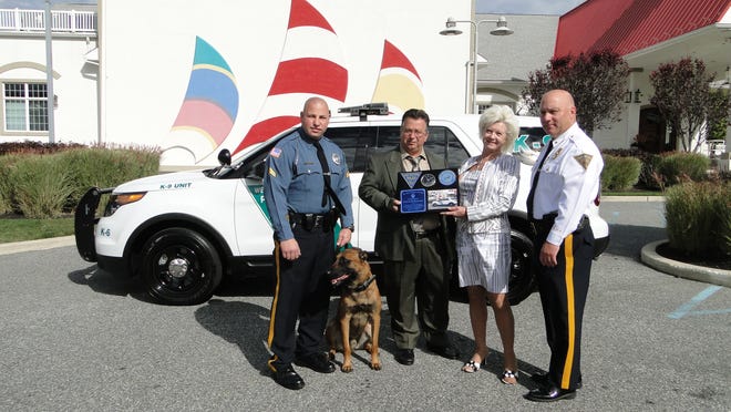 
West Deptford Cpl. Michael Franks (left), his K9 partner Tazor, and Chief Sam DiSimone present a plaque to Foti Farmakis and Helena Balius, Riverwinds Restaurant owners who donated $26,000 to the department for a K9 unit vehicle.
