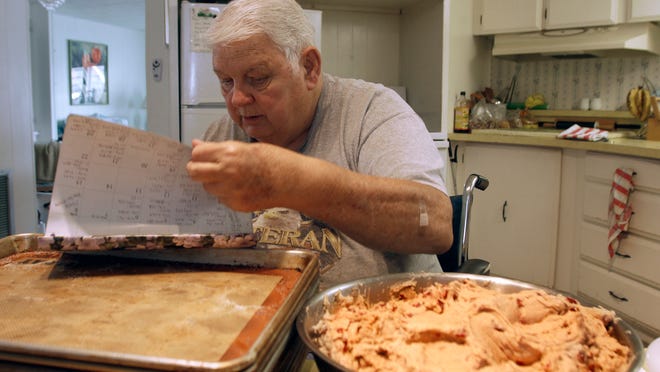 Charles Kellenberger looks through a calendar where he keeps a daily count of all the cookies he’s baked since Hurricane Charley in 2004 at his North Fort Myers home. Charlie has baked over half a million cookies.