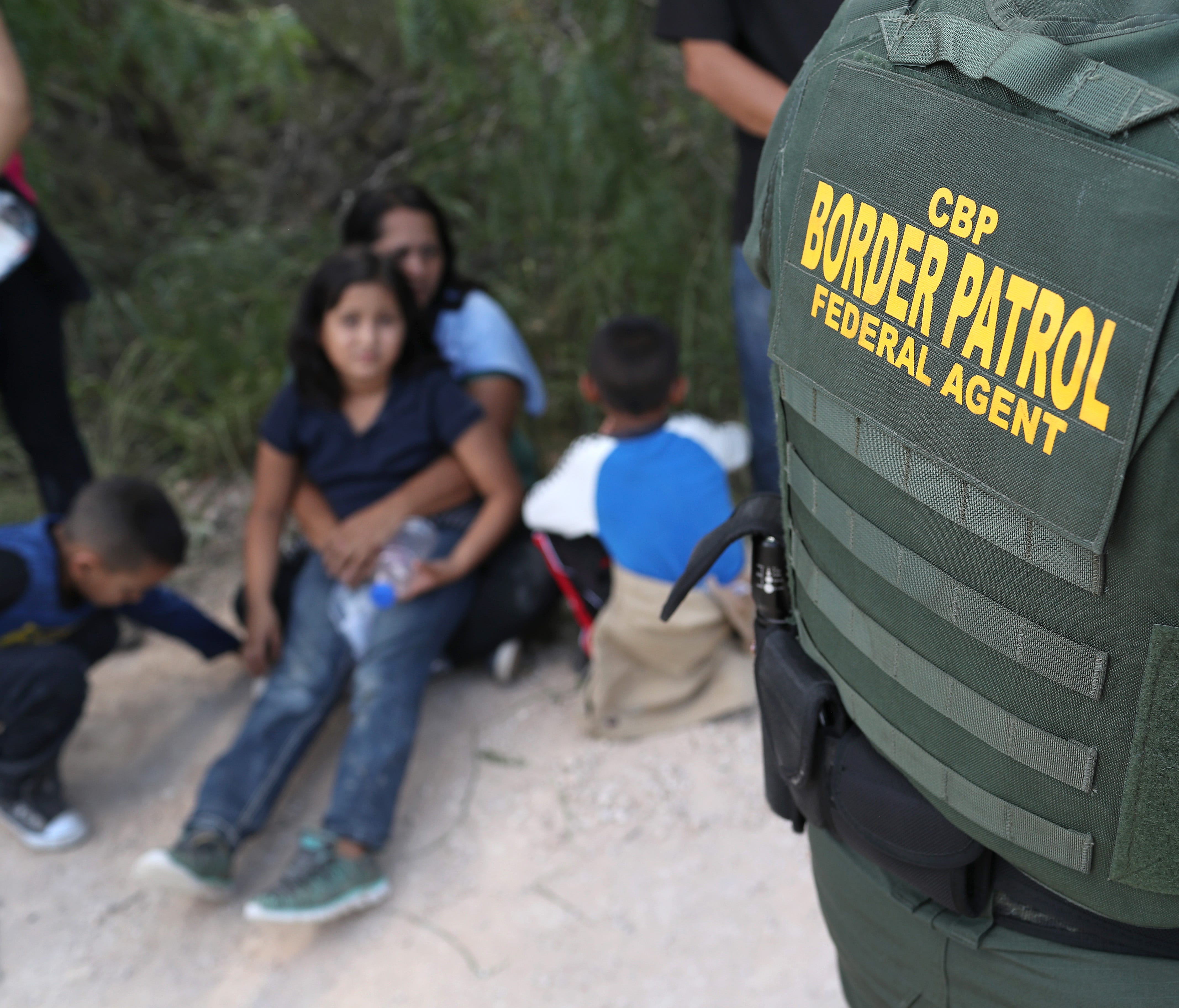 Central American asylum seekers wait as U.S. Border Patrol agents take them into custody on June 12, 2018 near McAllen, Texas.