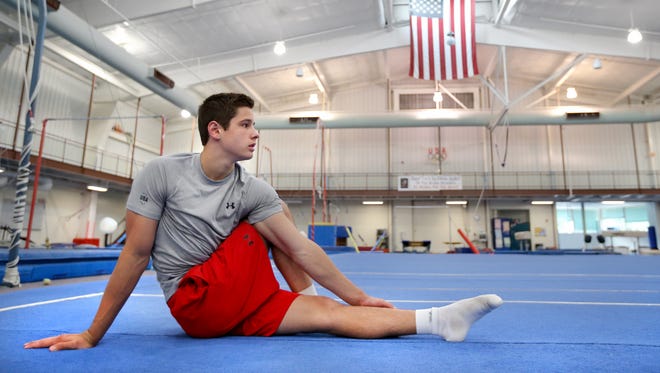 Gymnast Alec Yoder, 17 of Indianapolis, stretches before practicing his routines at the Interactive Academy in Zionsville on Friday, August 8, 2014. Yoder is traveling to Chine to compete in the Youth Olympic Games.