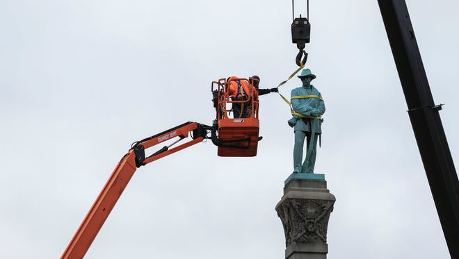 Messer Construction crews prepare the large Confederate monument for dismantling from the base Saturday morning on Third Street. The Confederate monument -- to honor confederate soldiers killed in the Civil War -- was first installed on Third Street in 1895. The monument is being moved to Brandenburg.