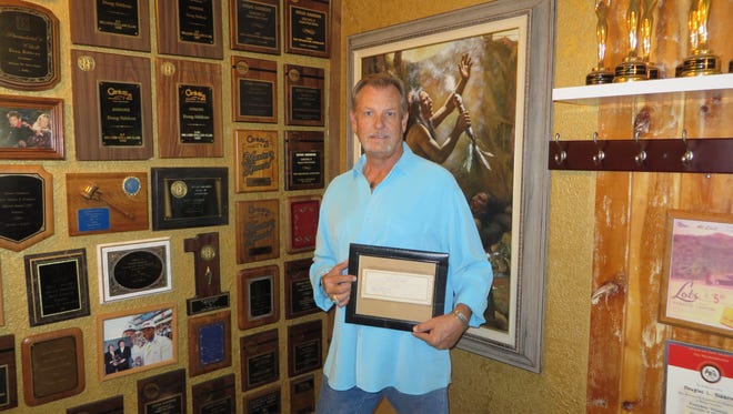 Broker Doug Siddens of Destiny Real Estate Development shows off some of the plaques and awards from a career that now spans 40 years.
