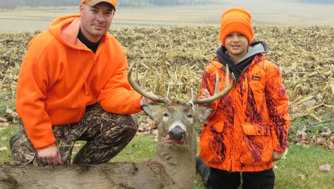Jeremy Schraufnagel, left, and Blake Schraufnagel, 10, of Mayville hold the buck that Blake shot on Saturday during the opening of gun deer season in 2014.