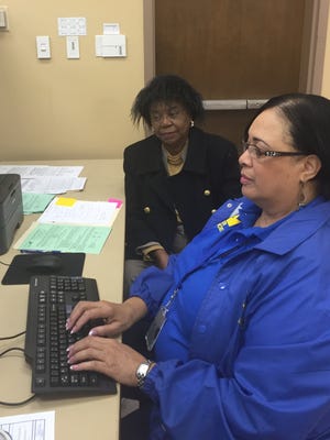 Clarice L. Isby provides her information to Catherine Walden with the Small Business Administration on March 21 at the Monroe Civic Center. Isby is requesting a low-interest loan to help restore her home after flooding.