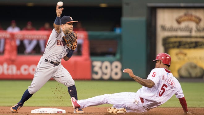 Houston Astros second baseman Jose Altuve, left, gets the force out at second on Philadelphia's Nick Williams, right, but was unable to turn the double play during the first inning Tuesday, July 25, 2017, in Philadelphia. The struggling Phillies are hoping to follow the Astros' example in rebuilding the franchise.