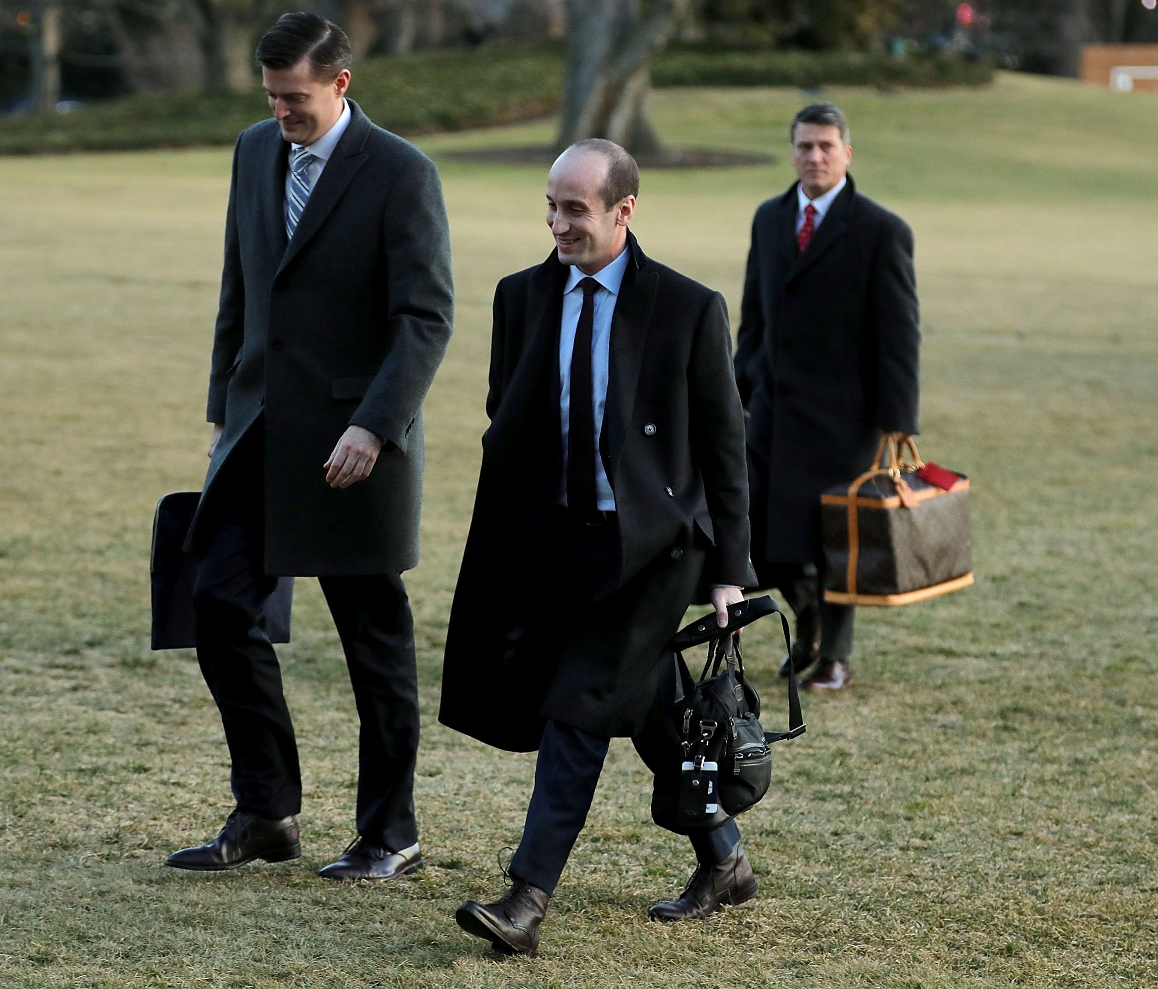 White House Staff Secretary Rob Porter (L) and Senior Advisor to the President Stephen Miller (C) return to the White House after a day trip with President Donald Trump to Cincinnati, Ohio, February 5, 2018 in Washington, DC. While in Ohio President 