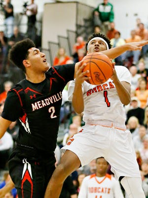 Northeastern's Brandon Coleman, right, takes the ball to the net while Meadville's Lashon Lindsey defends during PIAA Class 5-A boys' basketball semifinal action at Altoona High School Monday. The Bobcats lost the game, 56-49, ending their season a game short of the state finals. Dawn J. Sagert photo