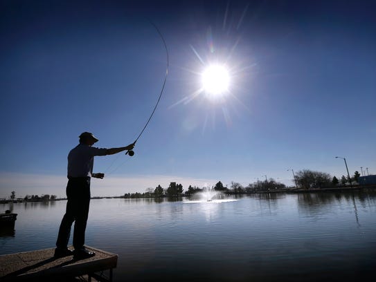 A man fishes at Ascarate Lake, in El Paso, Texas, Thursday,