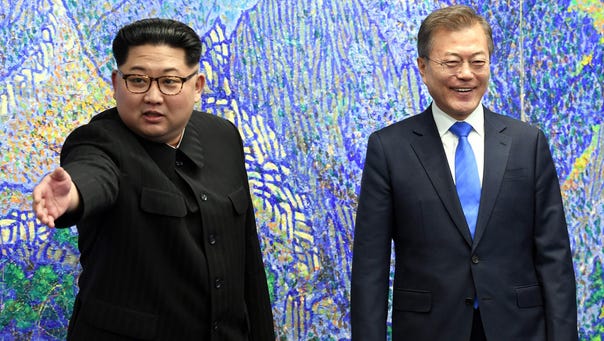 North Korea's leader Kim Jong Un (left) gestures next