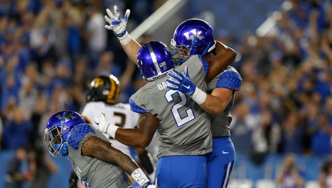 The Kentucky Wildcats' C. J. Conrad (87) celebrates with wide receiver Dorian Baker (2) after scoring a touchdown against the Missouri Tigers in the second half at Commonwealth Stadium. Kentucky defeated Missouri 21-13.