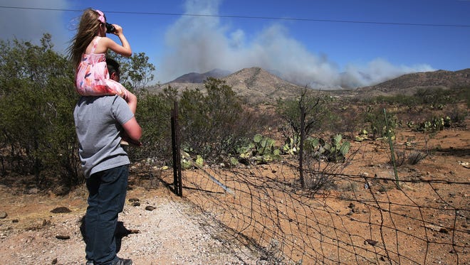 Corona de Tucson residents Leander Johnson and his 6-year-old daughter Alise, stop roadside to view the smoke as the Mulberry Fire burns east of State Route 83 southeast of Vail on May 6, 2017.