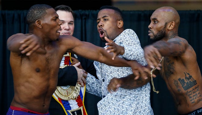 Promoter Langston Hampton (middle) tries to hold back boxers Lamar Harris (left) and Lanell Bellows (right) after they get into an altercation while facing-off during weigh-ins for their bout on the "Big Payback Championship Boxing FightÓ at the FedExFourm.