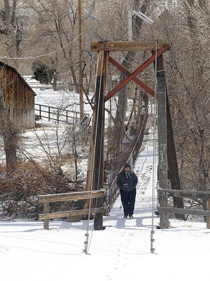 A pedestrian crosses a footbridge in Wadsworth, just north of Fernley.