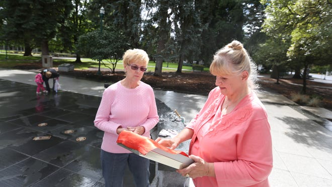 Charlotte King, right, meets with Mary Fisher at the World War II Memorial on Thursday, Sept. 17, 2015, in Salem, Ore. Fisher found a World War II service flag at a rummage sale with names handwritten next to three blue stars. King is the daughter of Grant Bowder, one of three brothers honored on the flag. Fisher returned the flag to King and her family.