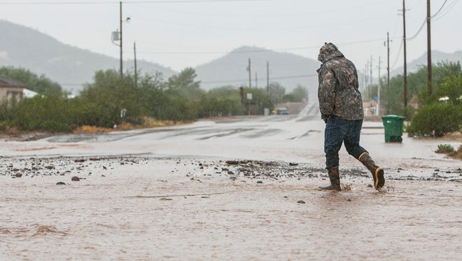 Resident Matt Tarver looks over 11th ave and W. Joy Ranch Road as flooding hits New River, AZ  on October 20, 2015.