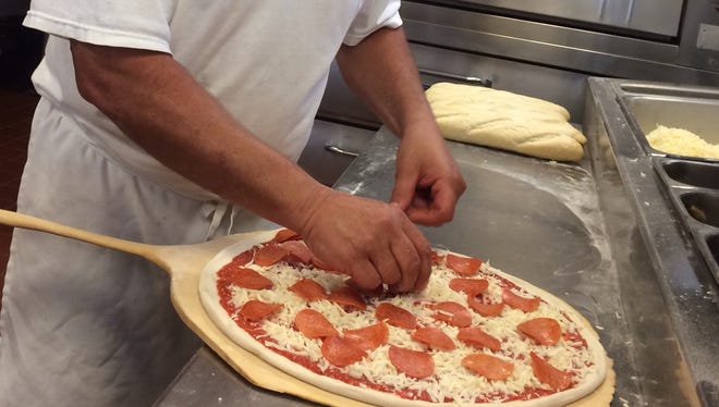 Joseph Minetti (he prefers Pepi) prepares a pie for the oven at his restaurant, Grandpa’s Pizza, in Bonita Springs.