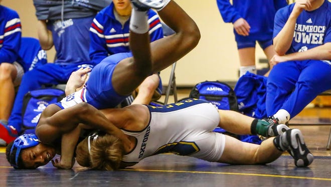 Catholic Central’s Kevon Davenport (left) prevailed 2-1 in his 125-pound match against Oxford’s Sergio Borg.