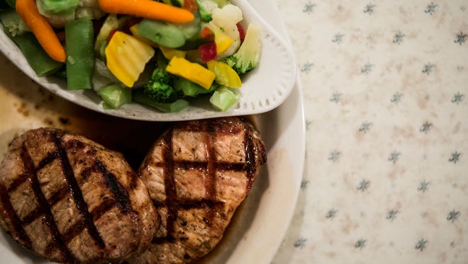 November 18, 2016 - Two grilled center cut pork chops and a vegetable medley at the Side Porch Steak House in Bartlett.