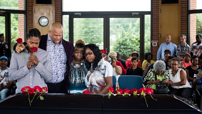 June 1, 2015 - Eric Henderson II, Eric Henderson, Valerie Henderson and Candice Henderson stand together over Calvin Wilhite's casket during a burial ceremony for the 26-year-old son, father, brother and Army veteran. "I just have no understanding, there's no reason my son was killed," Valerie said. Since the burial she hasn't been able to get out to his gravesite. "I just couldn't, I've tried twice," she said.