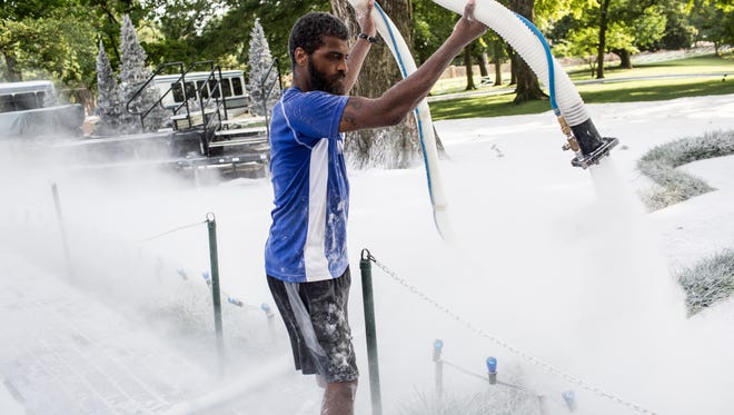 Justin Kelley works to transform the grounds around the mansion at Graceland into a winter wonderland for the filming of the Hallmark Channel’s new movie, “Christmas at Graceland,” in July 2018.