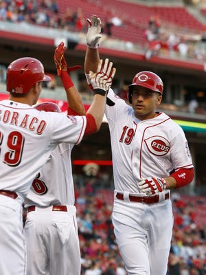 Cincinnati Reds' Joey Votto is congratulated by Devin Mesoraco (39) after Votto hit a two-run home run off St. Louis Cardinals starting pitcher John Lackey in the first inning of a baseball game, Friday, April 10