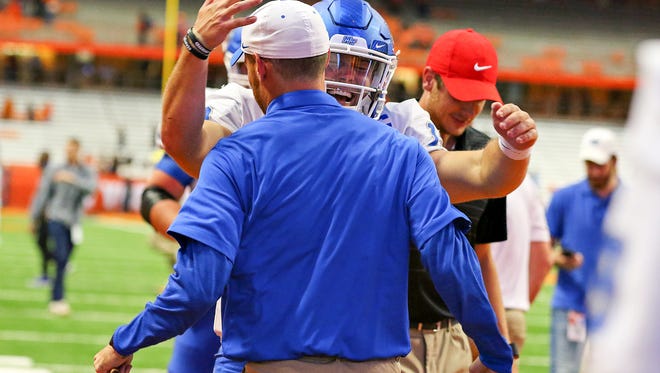 MTSU quarterback Brent Stockstill goes to hug grad assistant Wolfgang Shafer after MTSU's 30-23 win over Syracuse at the Carrier Dome in New York on Saturday.