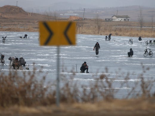 North Korean men ice fish on a frozen lake in Nampo,