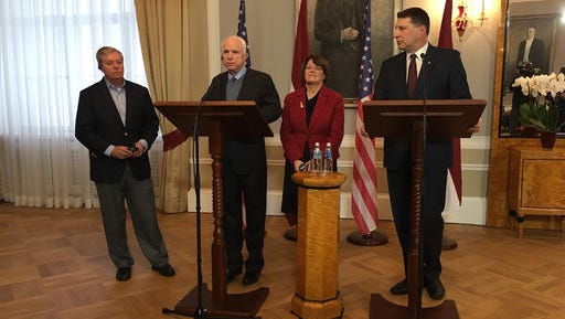 Latvian President Raimonds Vejonis, right, looks at  US Sen. John McCain centre left, during a press conference,  Wednesday, Dec. 28, 2016 in Riga, Latvia, while Lindsey Graham, R-SC., and Amy Klobuchar, D-Minn., stand in the background. Russia can expect hard-hitting sanctions from United States lawmakers if an investigation proves that Moscow interfered in the presidential election, a U.S. senator said Wednesday during a visit to Latvia.