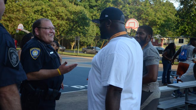 Chad Francisco, a Washington Heights Community Officer with the Battle Creek Police Department, talks to Sam Campbell, program director and summer coach of the Kalamazoo Lakeside Academy Titans, following a basketball game at Claude Evans Park on July 26, 2017.