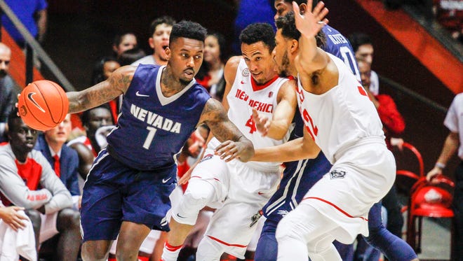 Nevada's Marcus Marshall tries to drive past New Mexico's Elijah Brown (4) and Tim Williams during their game earlier this month.