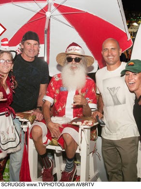 Surf legend and Cocoa Beach native Kelly Slater, second from right, posed with Terrie and Clifford "Peanut" Kuehner, the official Mr. and Mrs. Surfing Santa, and friends during a Cocoa Beach winter festival.