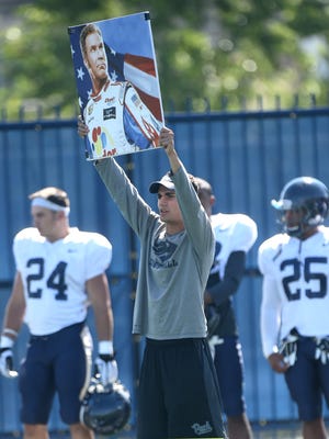 Nevada student assistant Mikahael Waters holds up a placard during Wolf Pack practice on Thursday.
