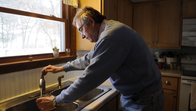 Town of Hull resident Dennis Bonikowski draws a glass of water in his kitchen in December 2013. He and his wife had to spend $6,000 digging a new well after their old well ran dry, a problem they and other Hull residents blame on a Stevens Point high-capacity well.