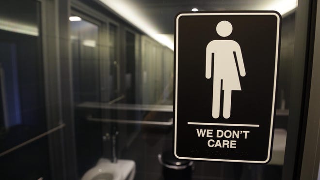 FILE- In this May 12, 2016 file photo, signage is seen outside a restroom at 21c Museum Hotel in Durham, N.C. North Carolina's deal to undo its "bathroom bill" is receiving a mixture of complaints and applause. The Atlantic Coast Conference announced Friday, March 31, 2017, that it's ready to start considering North Carolina again for future neutral-site championships, and some business leaders are praising the deal. (AP Photo/Gerry Broome, File)
