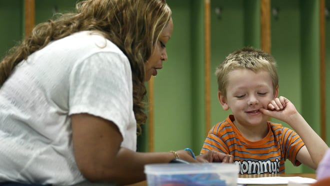 School No. 3 student Sean Dunham, who’s going into second grade, reacts as paraprofessional Doris Osborne cuts out drawings of living things including the cycle of plants. The program is a mix of students with and without disabilities.