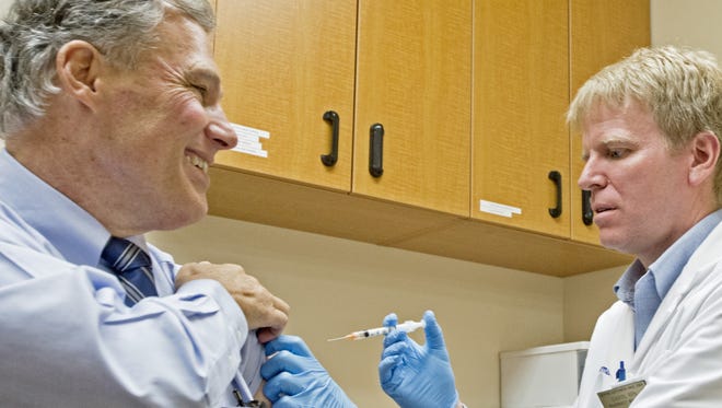 File photo
Lee Memorial Health System staffers will be required to get a flu shot this year.
While shortages of flu vaccine are  popping up, there is still vaccine available, the CDC  said.  Peter Haley/AP
Washington Gov. Jay inslee smiles as he receives a flu shot from pharmacist Darin Loose at Fred Meyer in Tumwater, Wash. Thursday, Jan. 24, 2013.  "I'm just allergic to pain," he quipped in response to the routine pre-vaccination question. (AP photo/The News Tribune, Peter Haley)