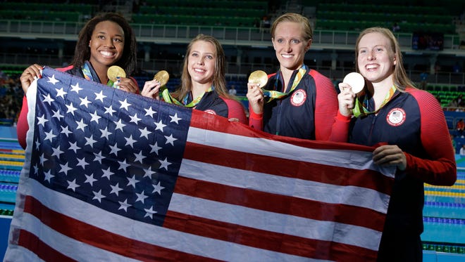 From right to left, United States' Lilly King, Dana Vollmer, Kathleen Baker and Simone Manuel display their gold medals for the women's 4 x 100-meter medley relay final during the swimming competitions Saturday at the 2016 Summer Olympics.