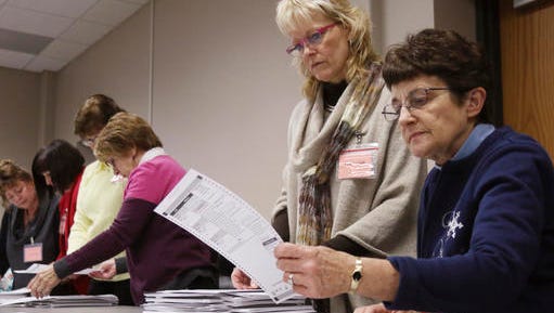 Tabulator Claudette Moll, right, from Farmington, looks over a ballot during a statewide presidential election recount Thursday, Dec. 1, 2016, West Bend, Wis.