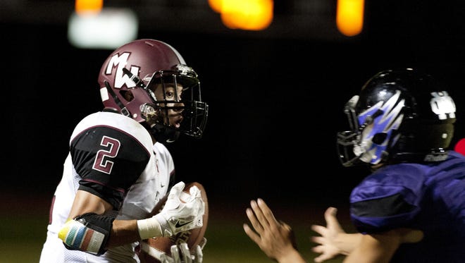 Mt. Whitney’s Jose Cisneros fends off Mission Oak’s Chris Leal at a football game between Mt. Whitney and Mission Oak.