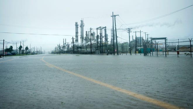 A view of the Marathon Texas City Refinery as rain from Hurricane Harvey floods a road on August 26, 2017 in Texas City, Texas. Hurricane Harvey slammed into the Texas coast late Friday, unleashing torrents of rain and packing powerful winds, the first major storm to hit the US mainland in 12 years.