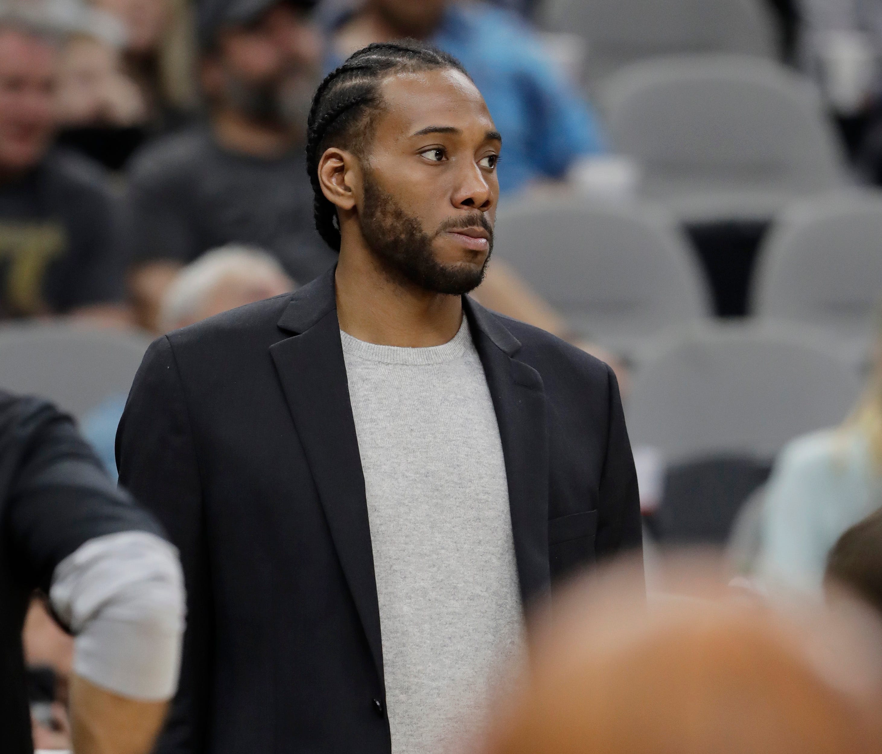 San Antonio Spurs forward Kawhi Leonard, waiting to return from injury, wears street cloths as he watches from the bench.
