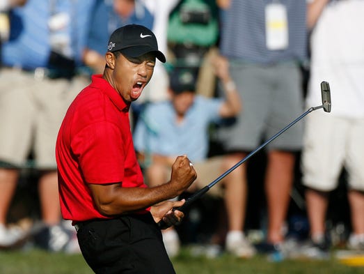 Tiger Woods celebrates after making a birdie on the