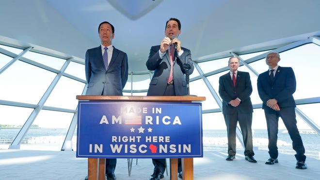 Foxconn Chairman Terry Gou, left, and Gov. Scott Walker speak during the Foxconn announcement at the Milwaukee Art Museum on July 27. Mark Hogan, second from right, secretary and CEO of the Wisconsin Economic Development Corp., and Gou's translator, Louis Woo, look on.