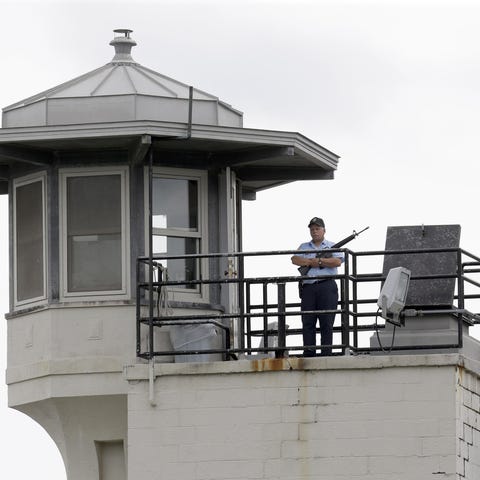A prison employee stands guard on a tower at the C