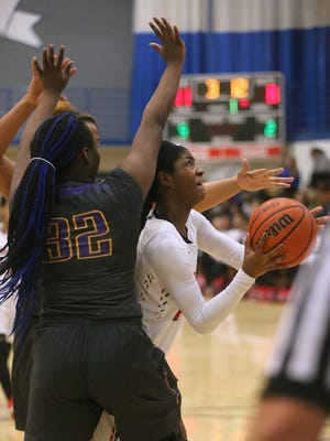 Stewarts Creek's Jamya Rogers (21) goes up for a shot as Smyrn'a Tyra Hughes (32) guards her during the District 7-AAA tournament play-in game on Thursday, Feb. 18, 2016, at La Vergne.