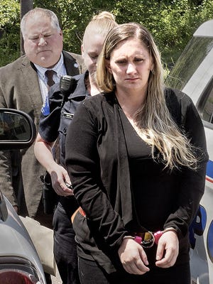 In a Friday July 13, 2018 photo, Samantha Jones, 30, is led into Magisterial Judge Jean Seaman's District Court in Warwick Township, Pa.,for her arraignment on homicide charges of killing her 11-month-old son through her drug-laced breast milk. (Kim Weimer/Bucks County Courier Times via AP)